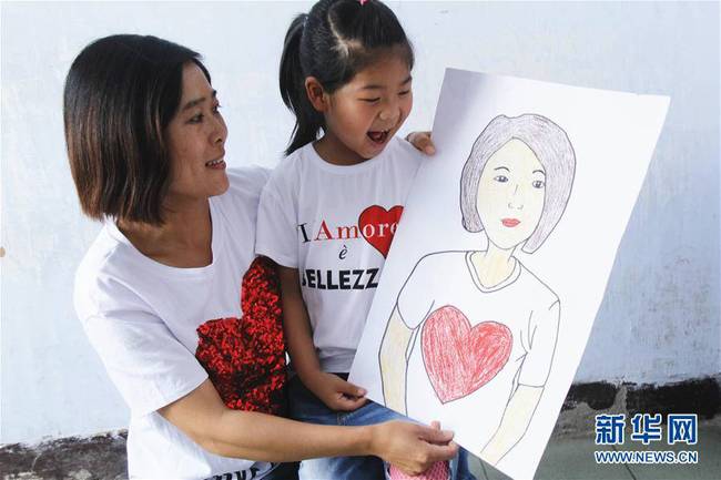 5月10日,，在河北唐山市豐潤(rùn)區(qū)迎賓路幼兒園開(kāi)展的“媽媽?zhuān)覑?ài)你”主題活動(dòng)中，陳悅寧小朋友將自己的繪畫(huà)作品送給媽媽作為節(jié)日禮物,。 新華社發(fā)（朱大勇 攝）