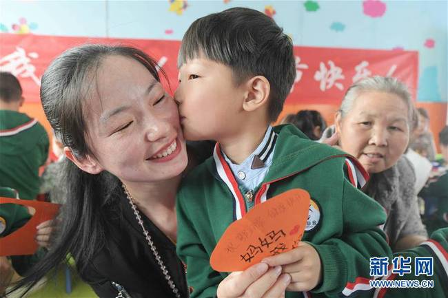 5月10日,，在湖北省襄陽(yáng)市一家幼兒園舉辦的母親節(jié)主題活動(dòng)中，一名小朋友將自己制作的賀卡獻(xiàn)給媽媽,。 新華社發(fā)（安富斌 攝）